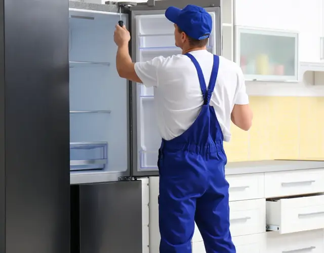 Técnico revisando el interior y las bisagras de una nevera